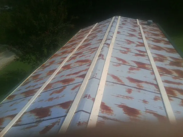 Rusted metal roof panels with new wood purlins before replacement — Storm Damage Roof Repair in Martins Creek by Roofing Brothers