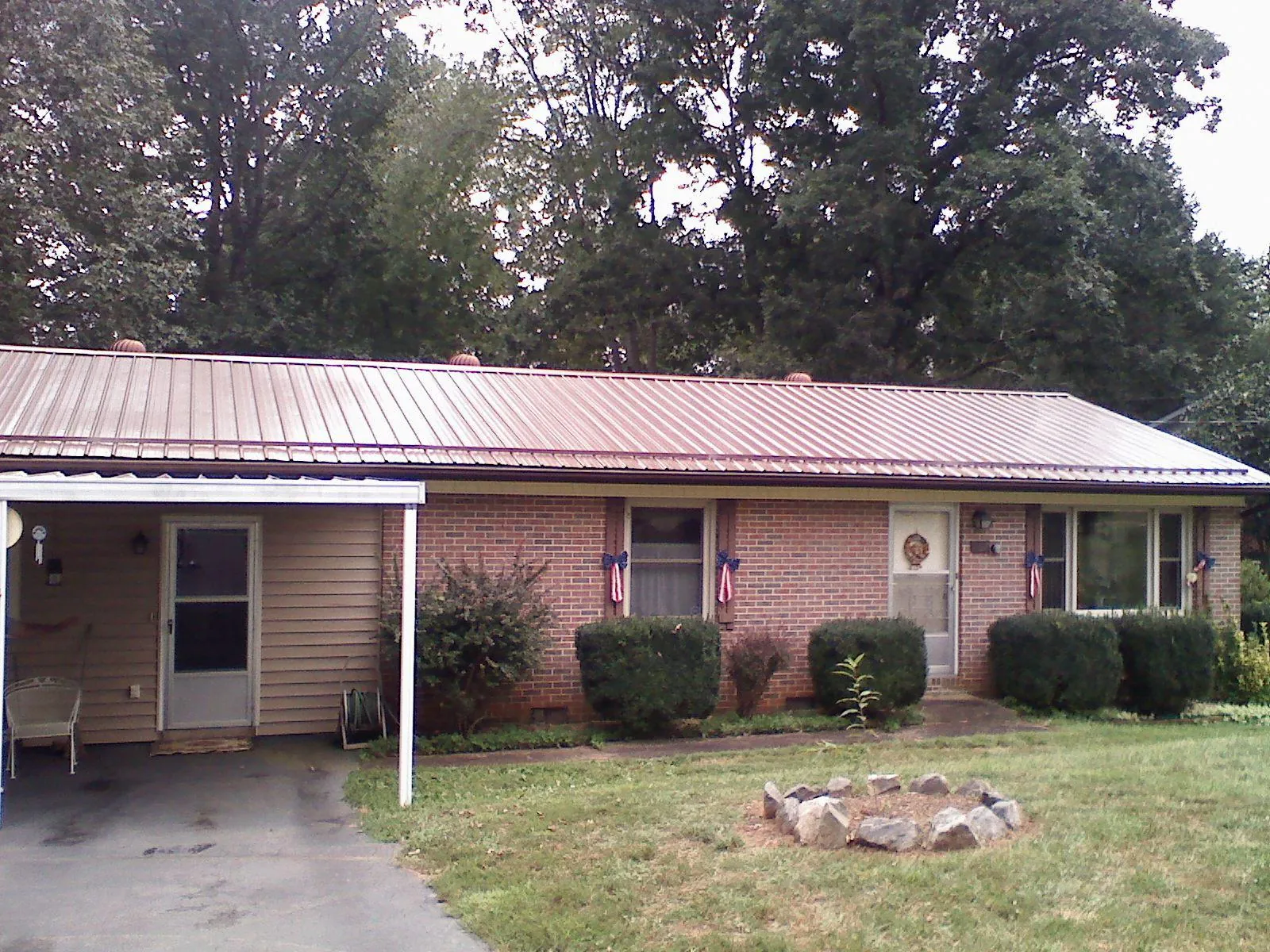 Bronze metal roof and carport on a brick ranch home — Roof Repair work by our crew in Martins Creek